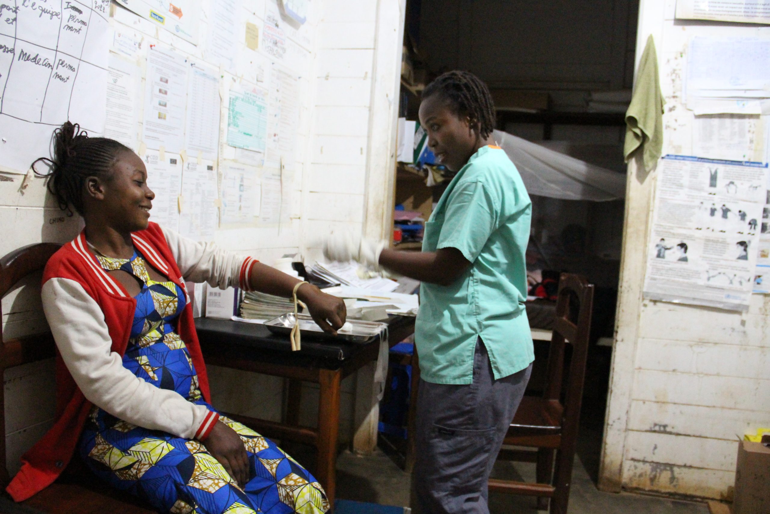 الممرض ألفونسين كاتسونغو يتفقد مريضا ليليا تحت الأضواء الساطعة في مرفق بويكين الصحي في بيني بجمهورية الكونغو الديمقراطية.